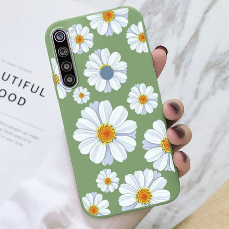 a woman holding a phone case with white flowers on it