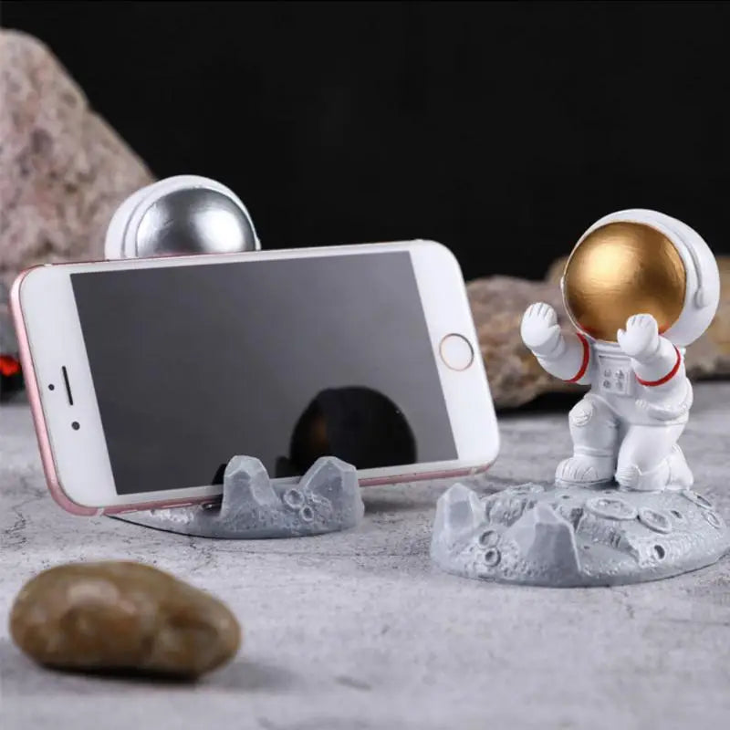 a small astronaut is holding a phone