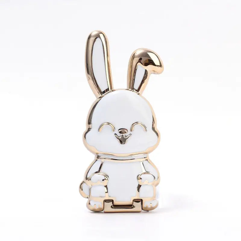 a white and gold rabbit pin with a black nose