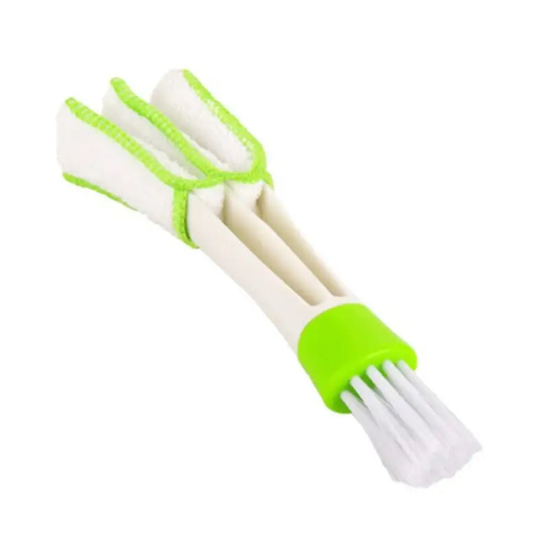 a white and green plastic brush with a green handle