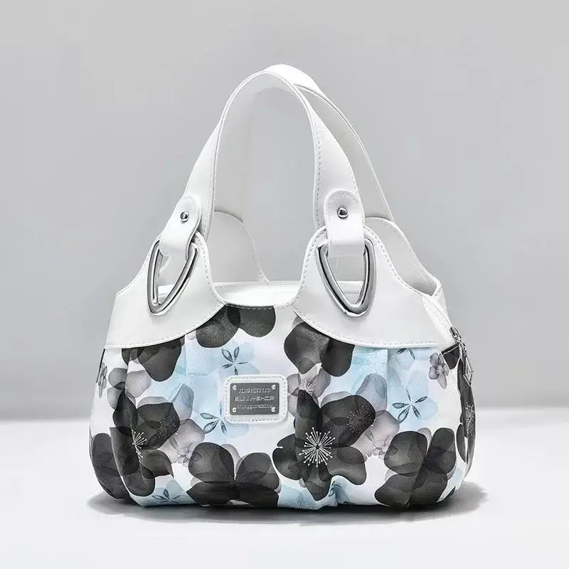 a white handbag with black and blue flowers