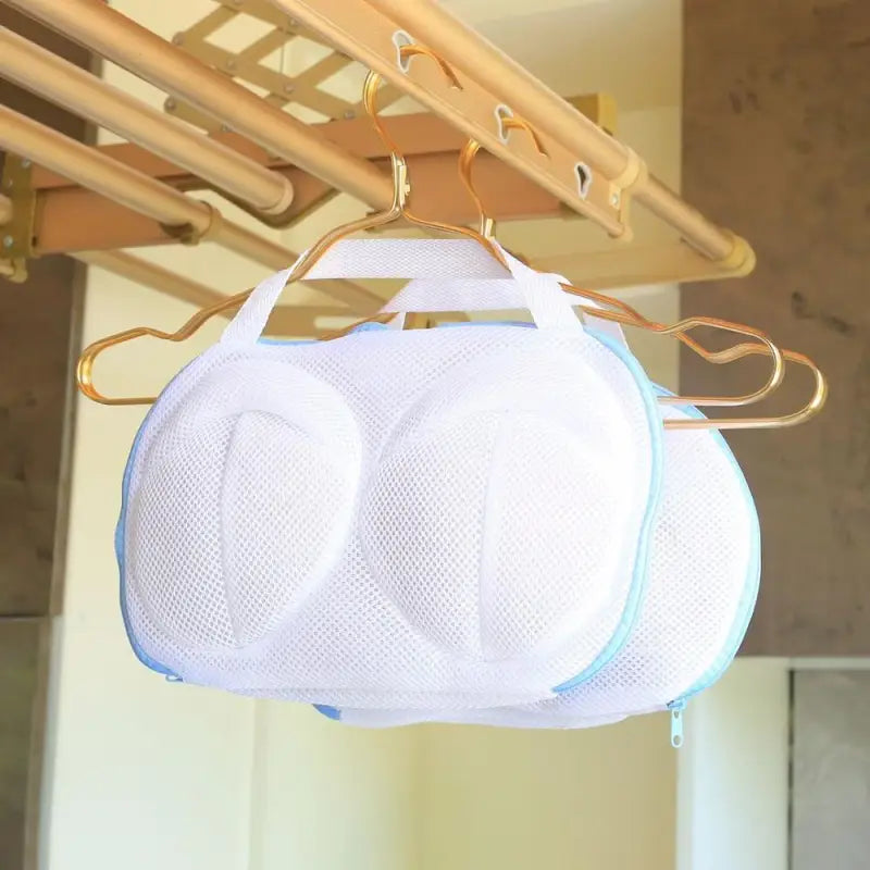 a white and blue mesh bag hanging from a wooden hanger