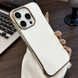 White iPhone 15 Pro Max with a gold-toned protective case.
