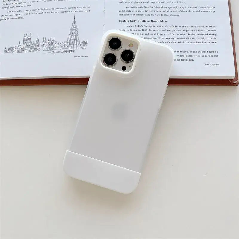 a white iphone case sitting on top of a book