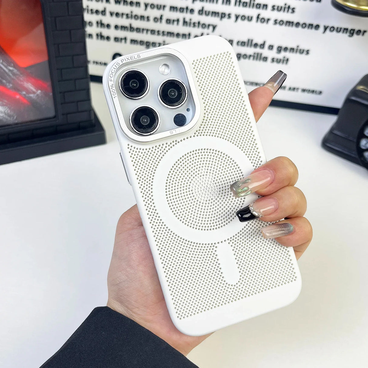 White iPhone case with a circular magnetic charging area and a triple-camera setup.