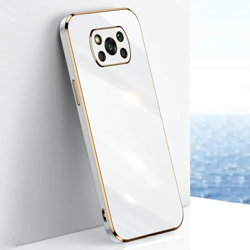 the back of a white iphone case with gold trim
