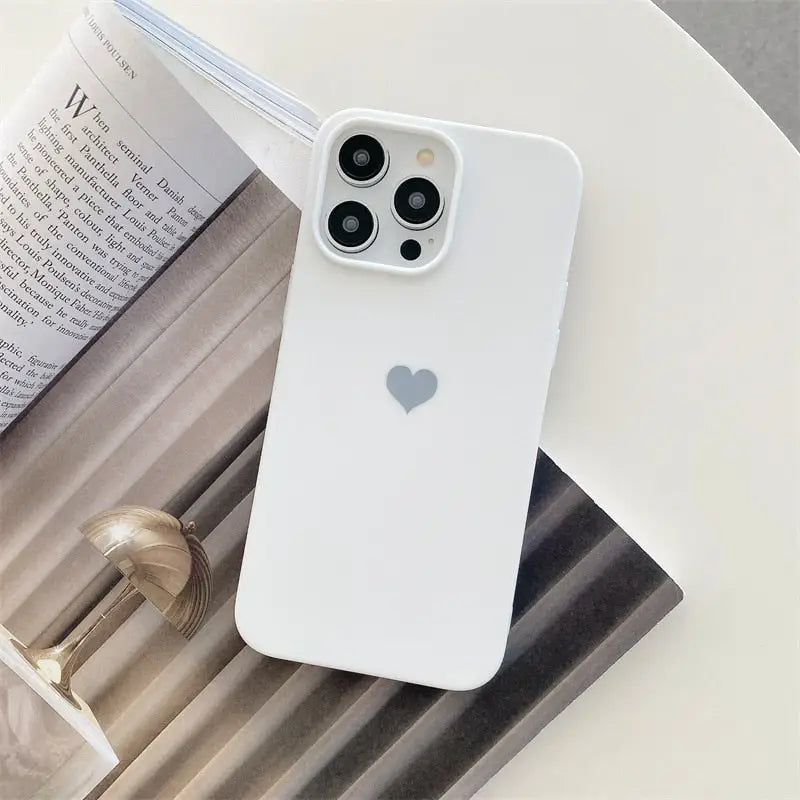 the white iphone case is sitting on a table next to a book