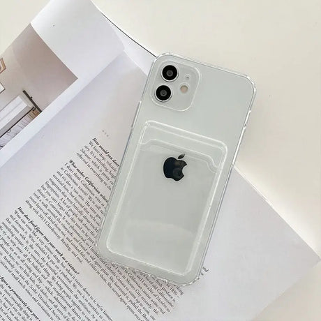 a white iphone case sitting on top of a book