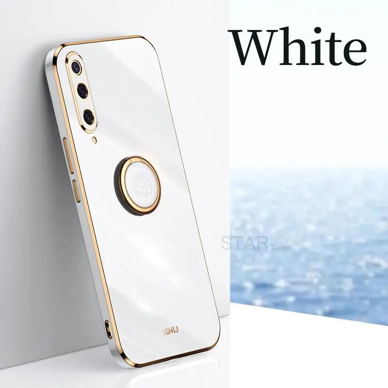 a white iphone with a gold ring on it