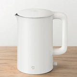 a white kettle on a wooden table