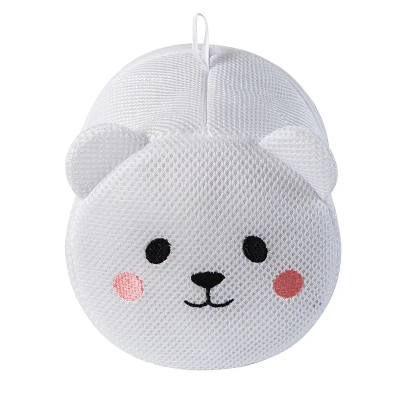 a white knitted bear toy with pink cheeks