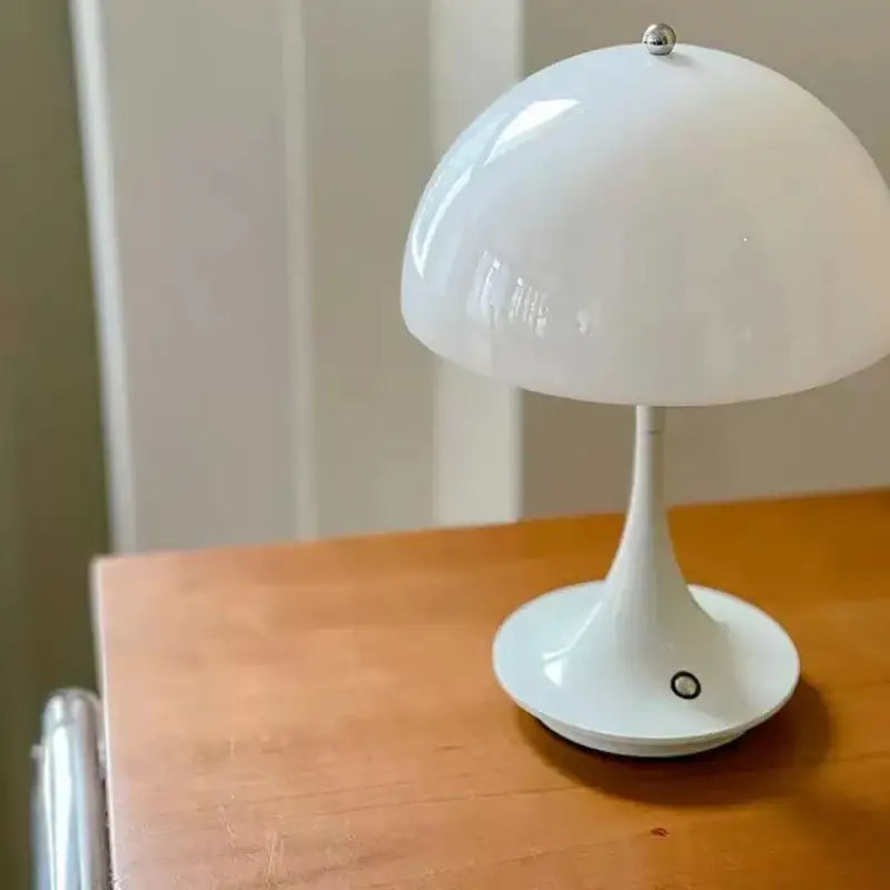 a white lamp sitting on top of a wooden table