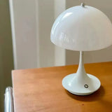 A white lamp sitting on top of a wooden table