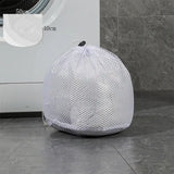 a laundry bag sitting on the floor next to a washing machine