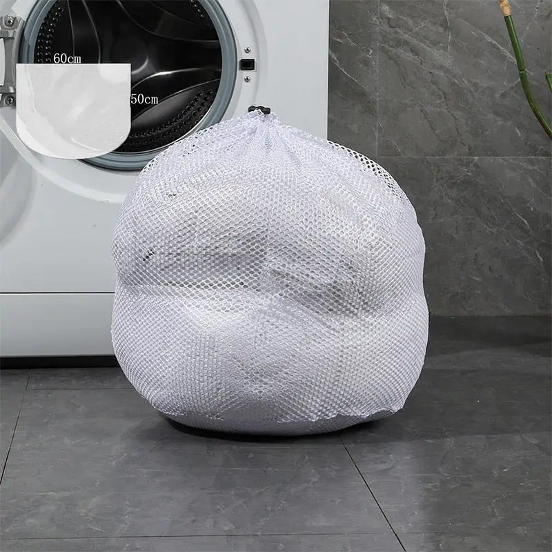 a white laundry bag sitting on the floor next to a washing machine