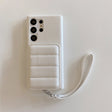 White leather smartphone case with a card holder and wrist strap.