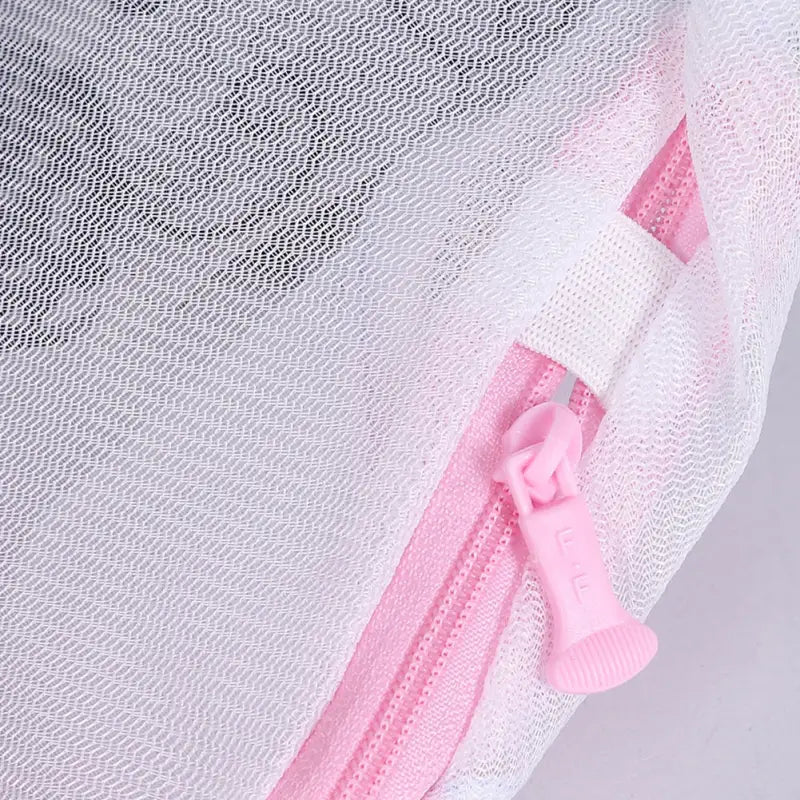 a white mesh mesh fabric with pink ribbon