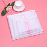 a white mesh bag with a pink ribbon and a cup of coffee