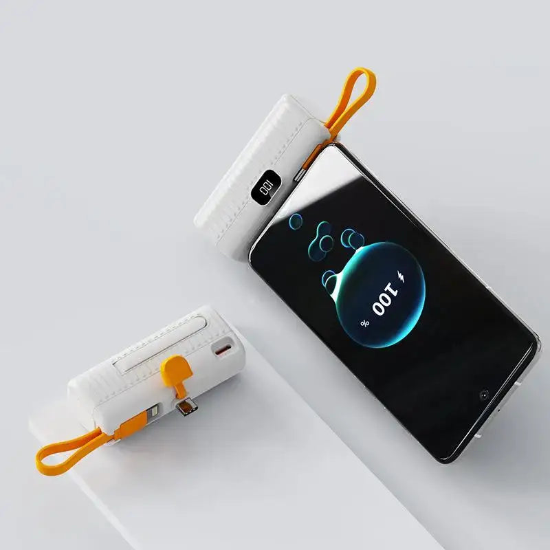 a white and orange phone with a charging cable attached to it