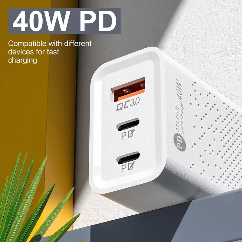 a white wall outlet with a plant in the corner