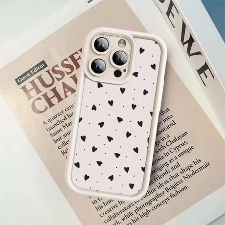 a white phone case with black hearts on it