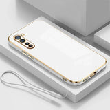 a white phone case with gold trim and a white cable