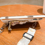 A white phone case with a white strap