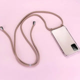 a white phone with a silver strap on a pink background