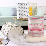 a white table topped with a white feather and a white and pink patterned paper lantern