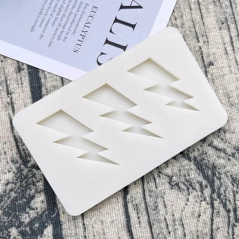 a white plastic coaster with a white geometric design
