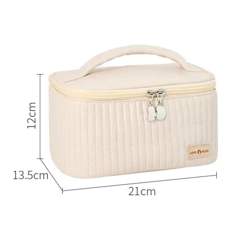 the white quilted cosmetic bag with a zipper closure