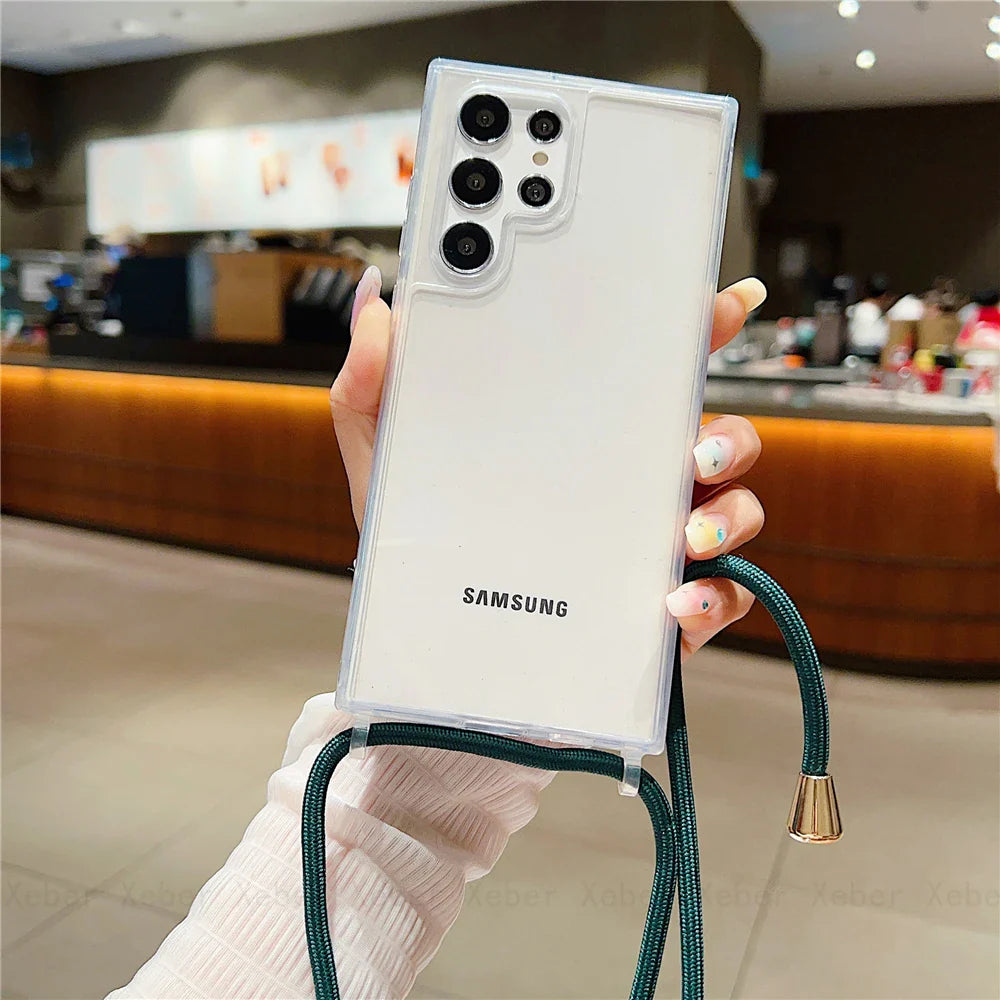 A white Samsung smartphone in a clear case with a dark green lanyard.