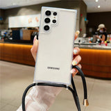 A white Samsung smartphone in a clear case with a black lanyard.