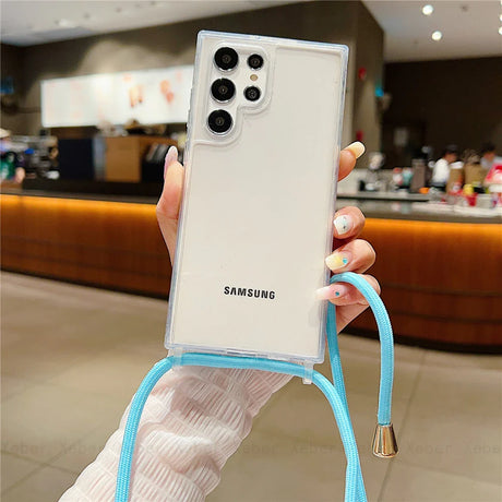 White Samsung smartphone with a clear case and blue lanyard.
