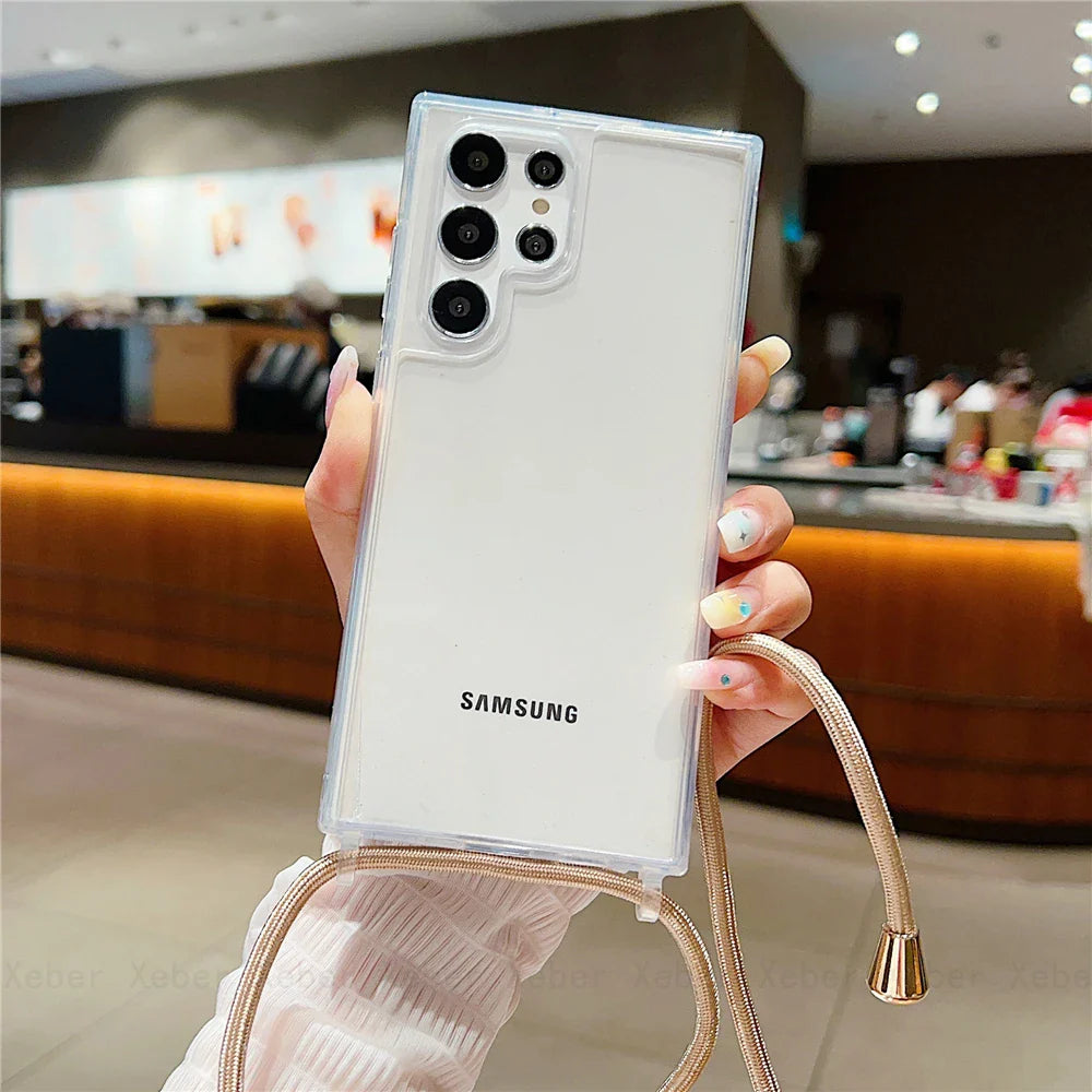 White Samsung smartphone with a clear case and a crossbody strap.