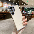 White smartphone with a light purple camera module and trim, held by a hand with decorated nails.