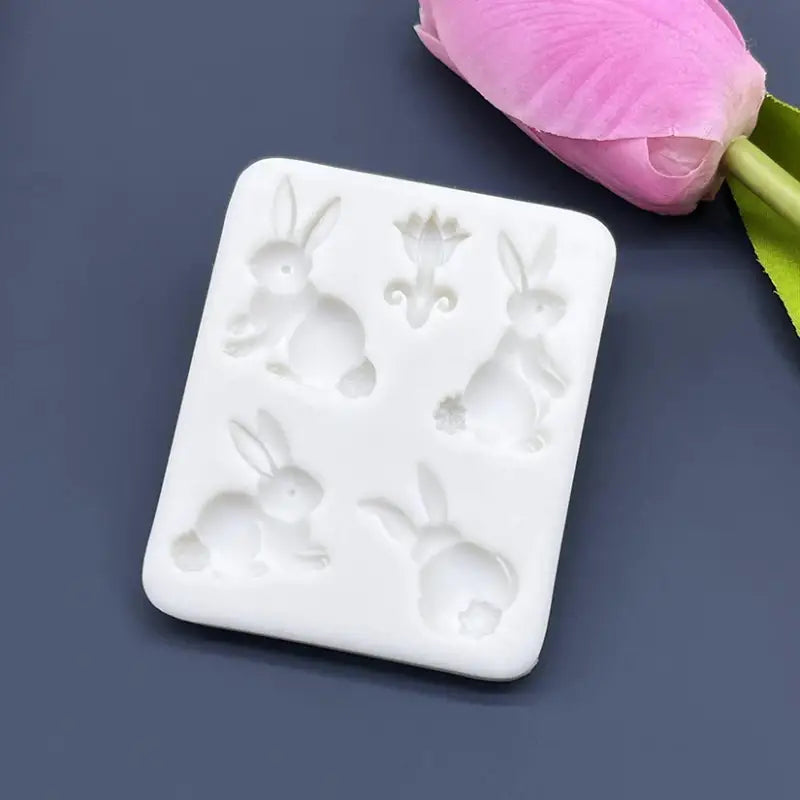 a white soap bar with a pink flower on top