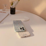 a white table with a white vase and a phone