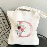 a white tote bag with a floral mono