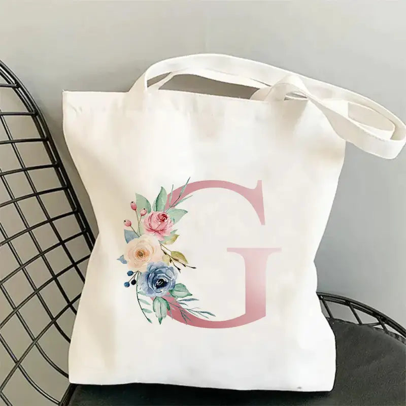 a white tote bag with a floral mono