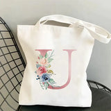 a white tote bag with a floral initial