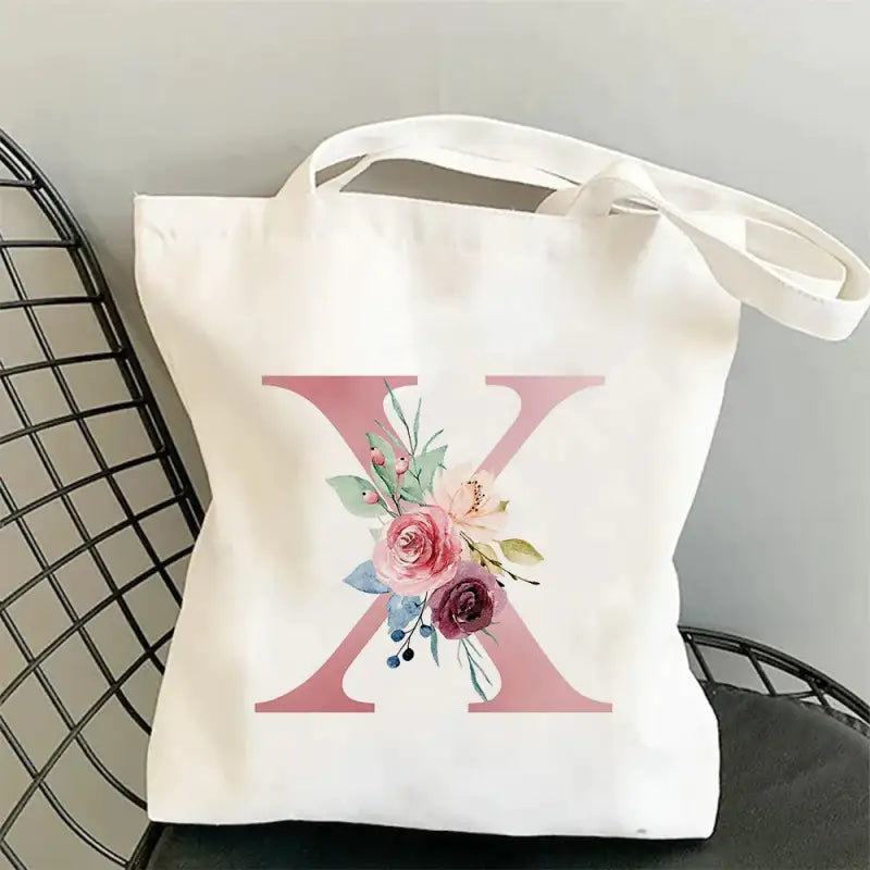 a white tote bag with a pink flower on it