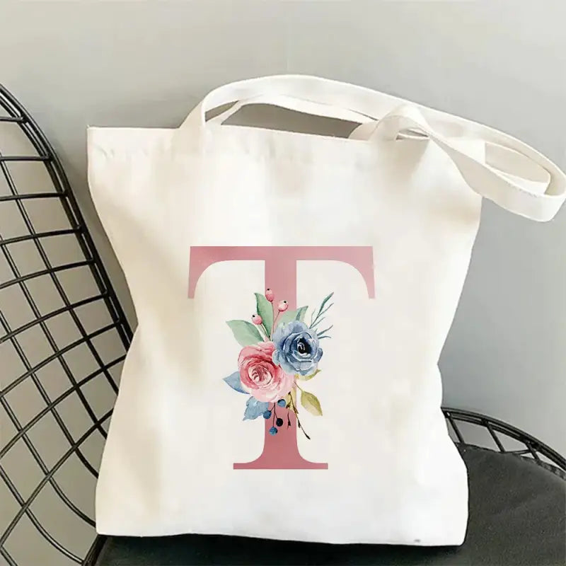 a white tote bag with a pink and blue flower on it