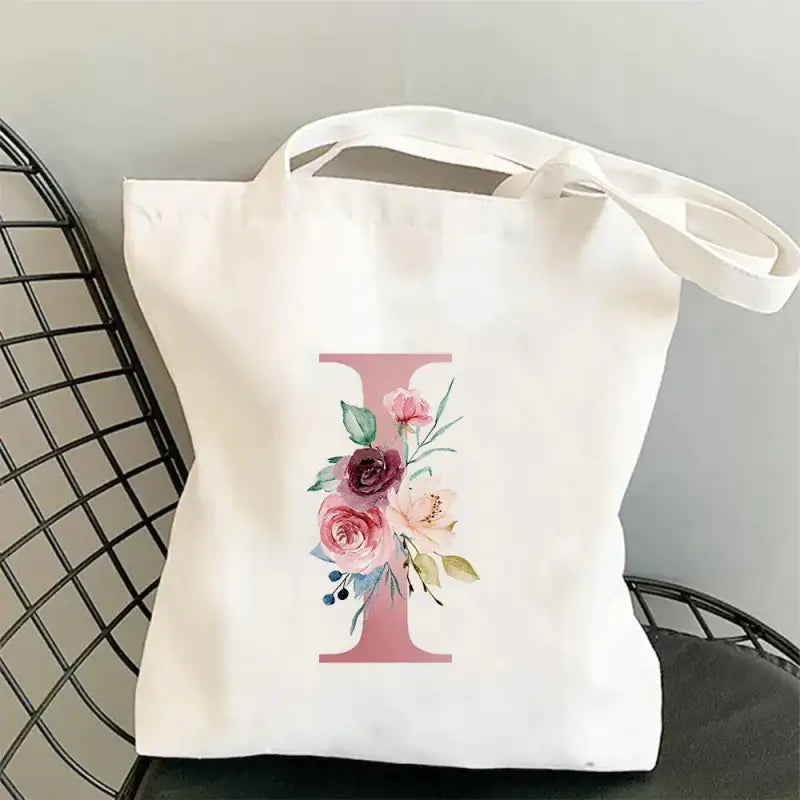 a white tote bag with a pink flower design