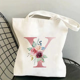 a white tote bag with a pink flower on it