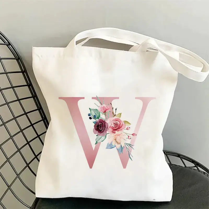 a white tote bag with a pink flower design