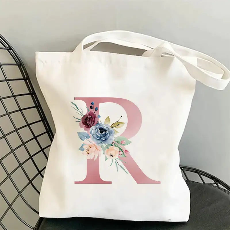 a white tote bag with a pink and blue flower design