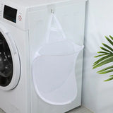 a white washing machine sitting next to a plant