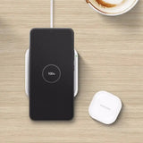 a white wireless mouse and a black wireless mouse on a wooden table