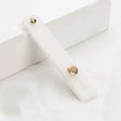 A white wooden box with a gold button